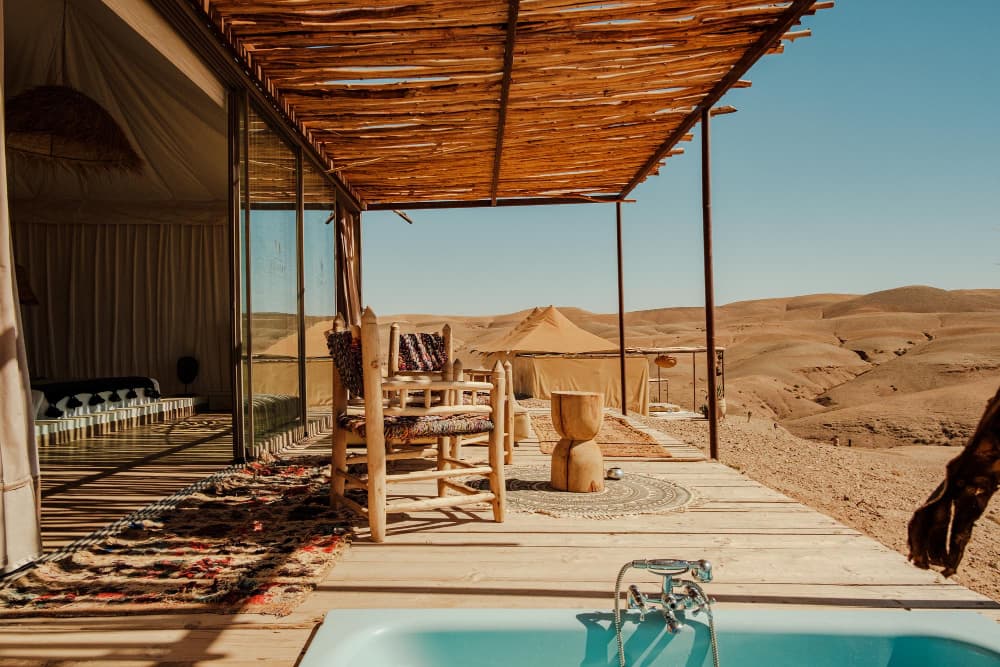 Desert glamping lodge terrace with a plunge pool overlooking dunes