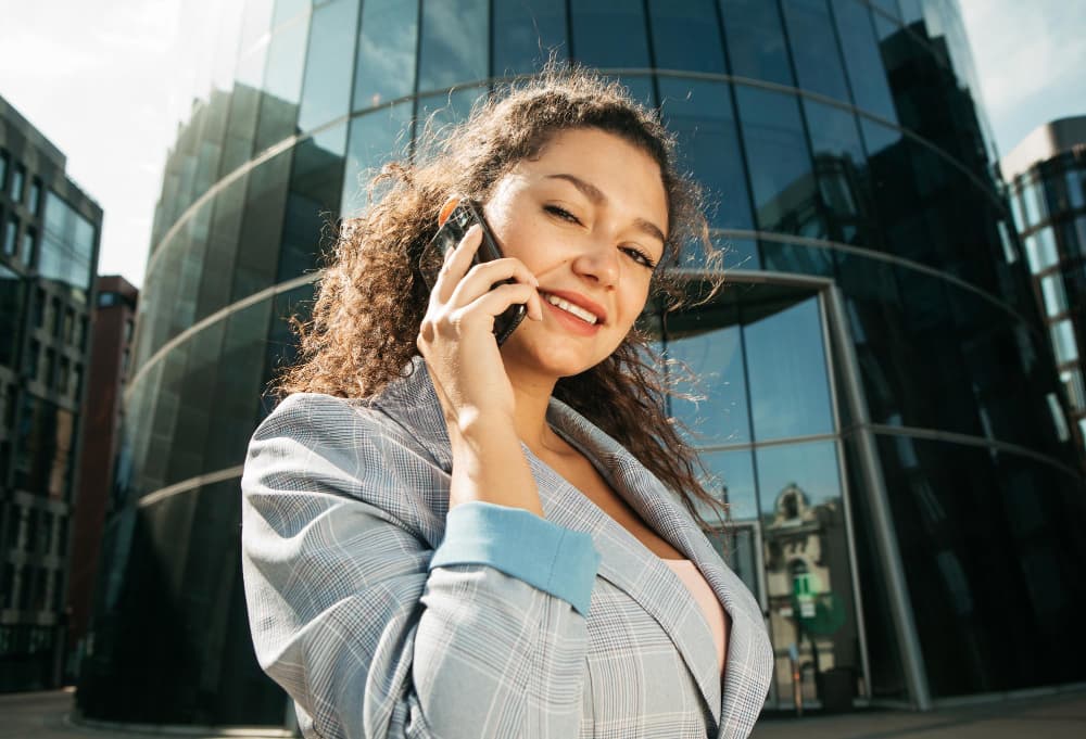 Woman making an international call on her phone in a city street
