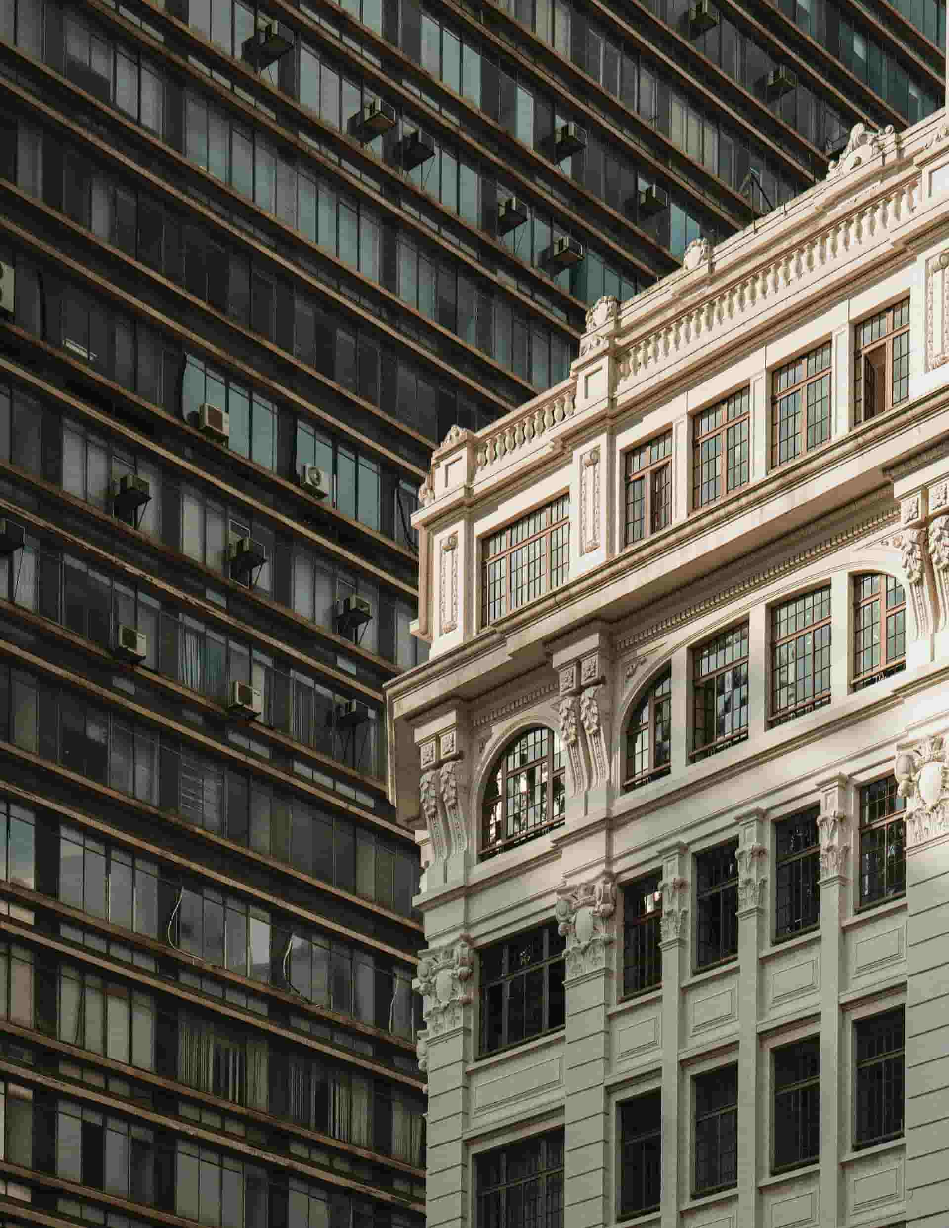Ornate stone office building beside a modern glass tower