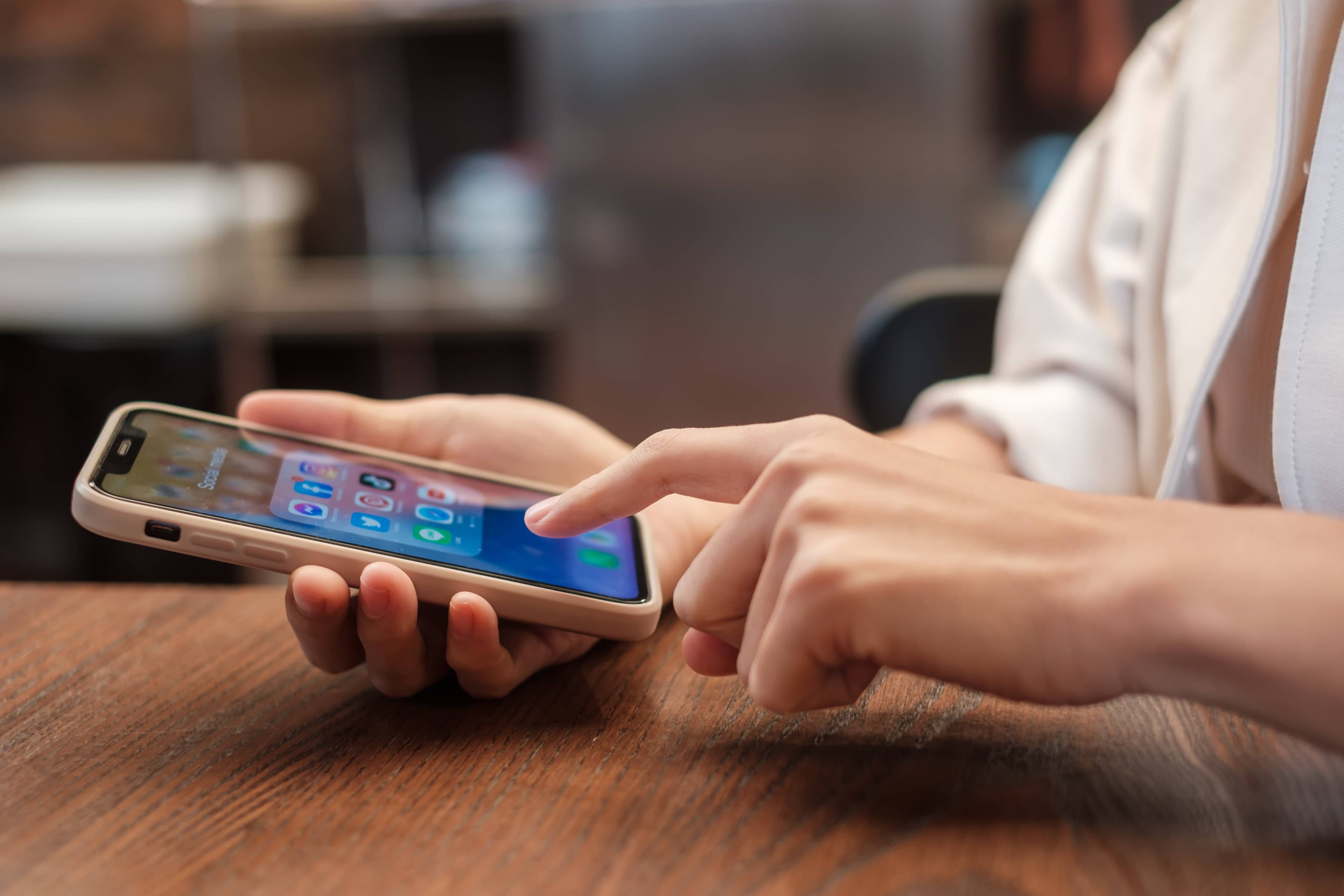 Person tapping an app on their phone's home screen